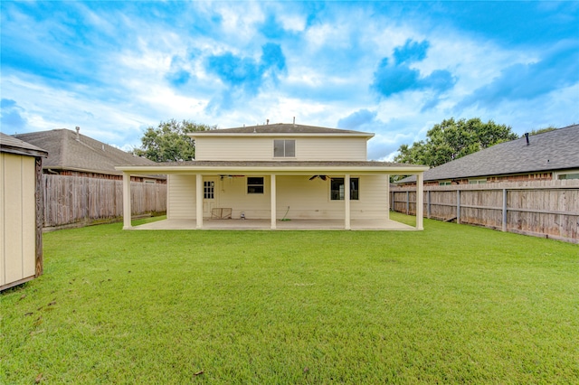 rear view of property featuring a lawn, ceiling fan, and a patio area