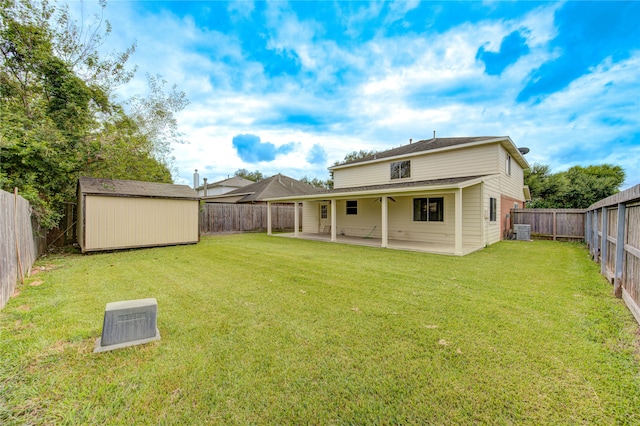 back of house featuring a shed, a yard, a patio, and central AC