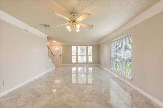 empty room with ceiling fan, a textured ceiling, and ornamental molding