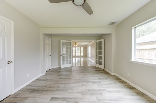 unfurnished room with ceiling fan, light wood-type flooring, and french doors