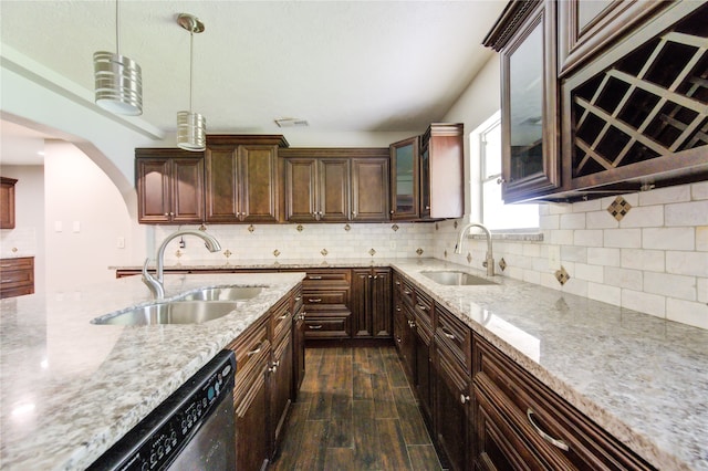 kitchen featuring dark wood-type flooring, decorative light fixtures, light stone countertops, and sink