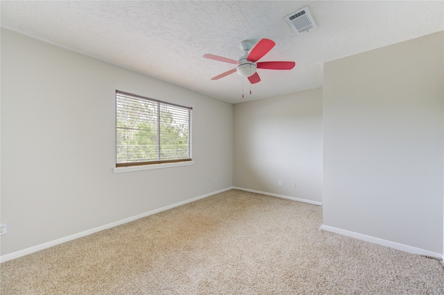 carpeted empty room with a textured ceiling