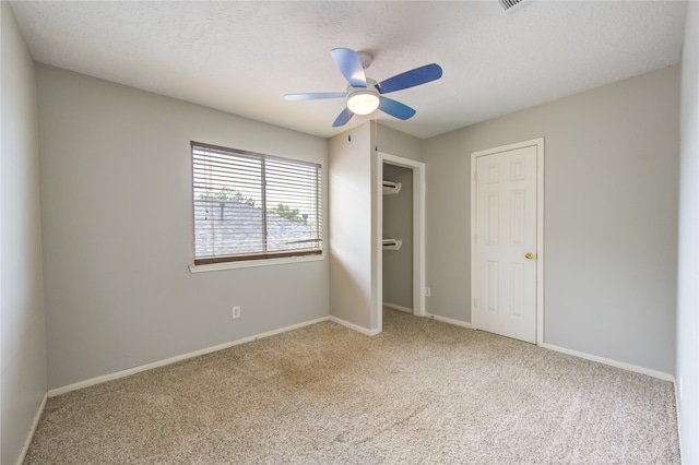 unfurnished bedroom featuring ceiling fan, a textured ceiling, and light carpet