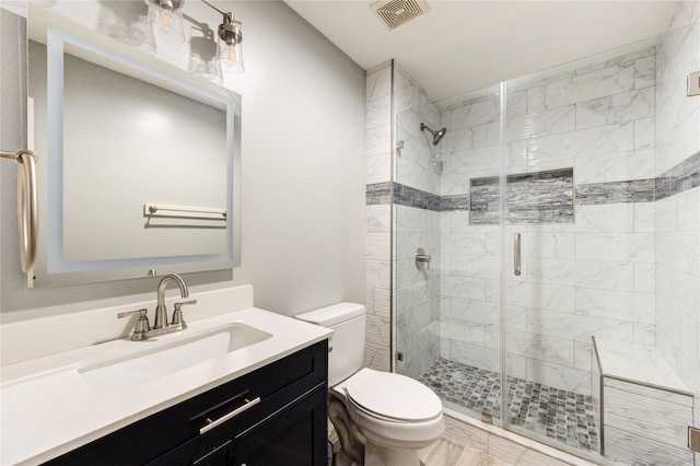 bathroom with toilet, vanity, and walk in shower