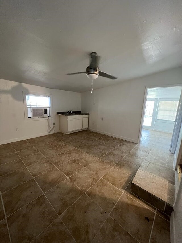 spare room featuring plenty of natural light, cooling unit, and ceiling fan