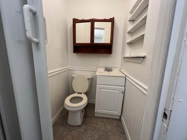 bathroom featuring toilet, vanity, and tile patterned flooring