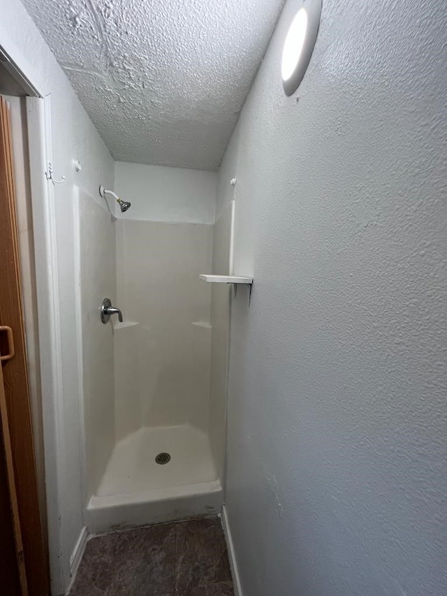 bathroom featuring a shower and a textured ceiling