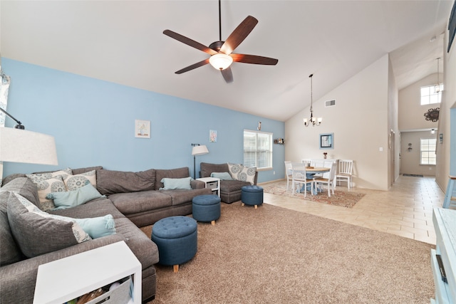 carpeted living room featuring ceiling fan with notable chandelier, high vaulted ceiling, and plenty of natural light