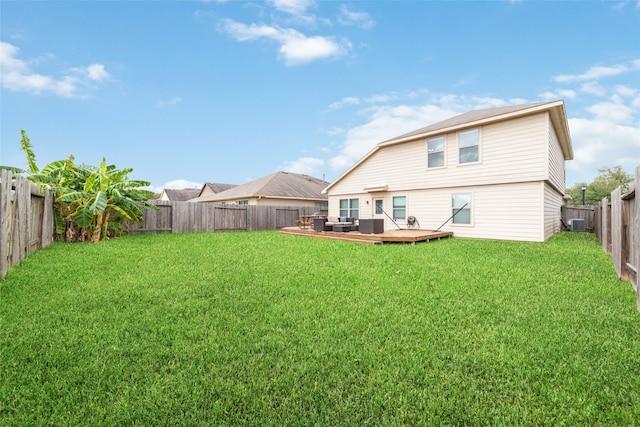 rear view of property featuring outdoor lounge area, a yard, and a wooden deck