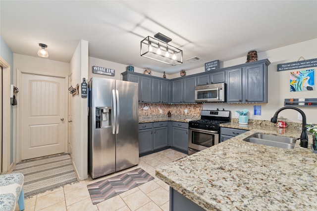 kitchen featuring decorative backsplash, light tile patterned floors, sink, and appliances with stainless steel finishes