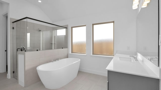 bathroom featuring a stall shower, a freestanding tub, vaulted ceiling, and vanity