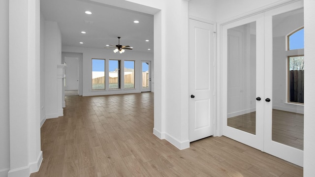 hallway with recessed lighting, french doors, and light wood finished floors