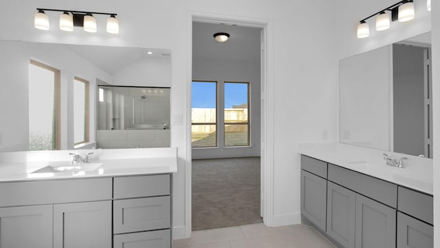 bathroom with a stall shower, two vanities, and a sink