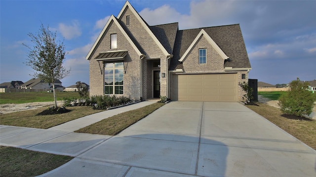 view of front facade with a front yard, concrete driveway, brick siding, and roof with shingles