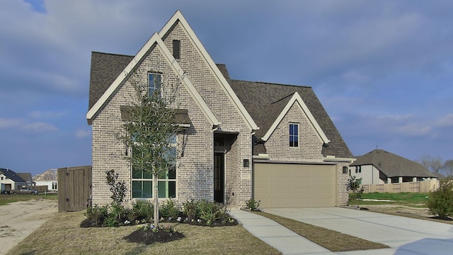 view of front of home featuring a garage, driveway, brick siding, and a shingled roof