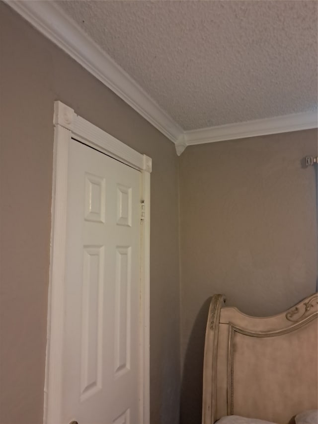 interior space featuring a textured ceiling and ornamental molding