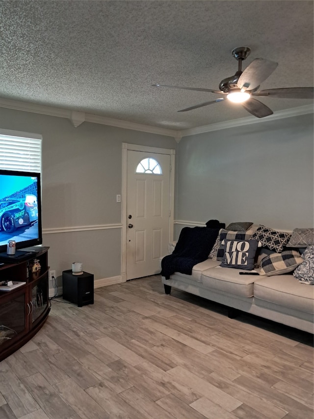 living room with ornamental molding, a textured ceiling, hardwood / wood-style flooring, and a healthy amount of sunlight