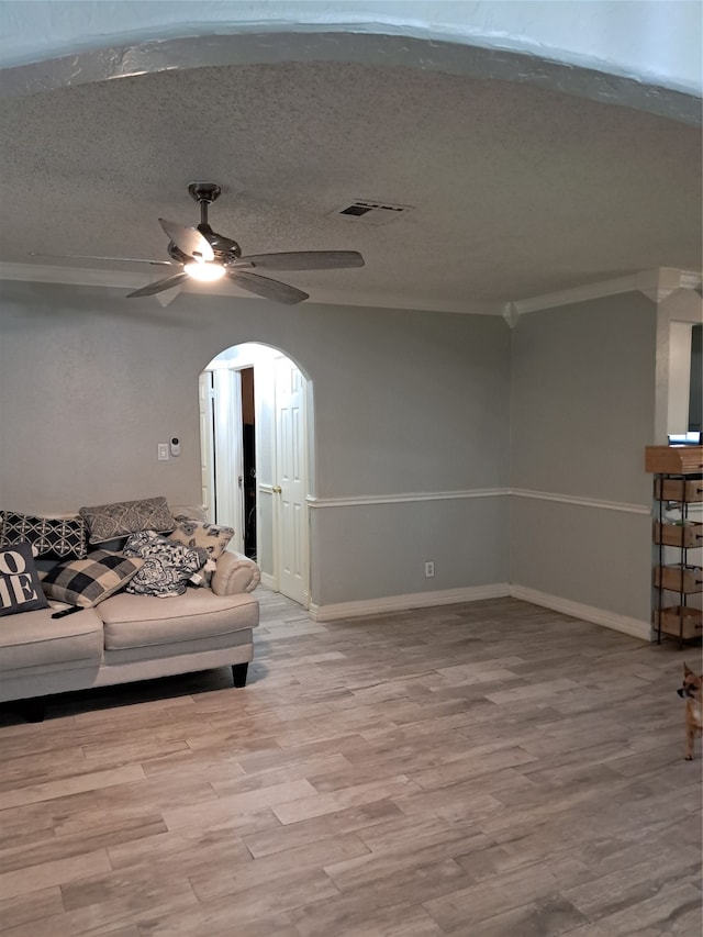 living room with ceiling fan, a textured ceiling, and light hardwood / wood-style flooring