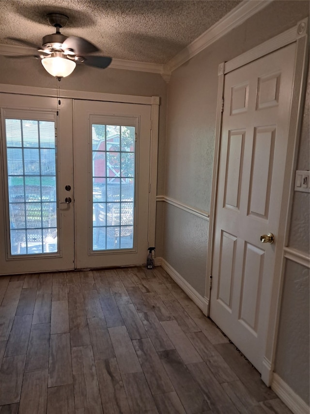 doorway with ceiling fan, french doors, crown molding, wood-type flooring, and a textured ceiling