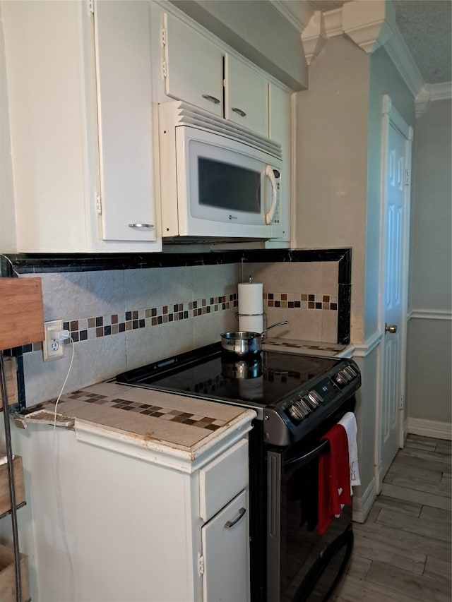 kitchen with white cabinets, white appliances, crown molding, and tasteful backsplash