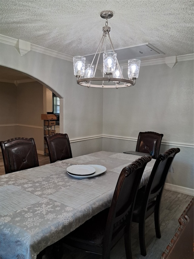 dining area featuring crown molding, hardwood / wood-style floors, and a textured ceiling