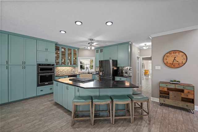 kitchen with sink, a center island, light hardwood / wood-style floors, appliances with stainless steel finishes, and ornamental molding