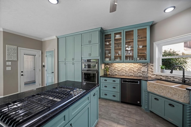 kitchen featuring sink, tasteful backsplash, light wood-type flooring, appliances with stainless steel finishes, and ornamental molding