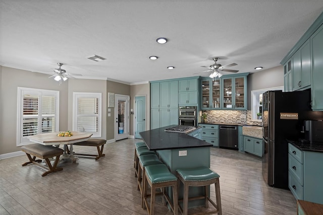 kitchen featuring black appliances, backsplash, wood-type flooring, and crown molding