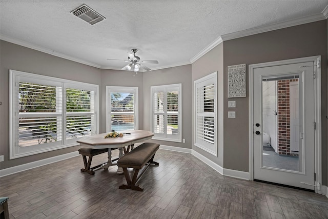 dining area featuring a wealth of natural light, a textured ceiling, and hardwood / wood-style flooring