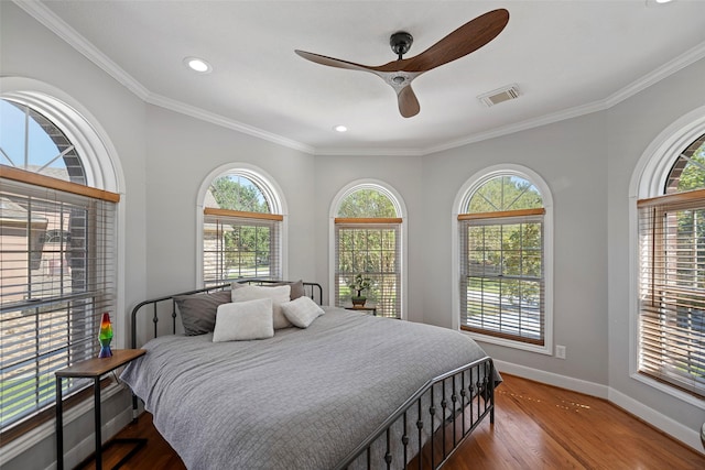 bedroom featuring multiple windows, dark wood-type flooring, and ceiling fan