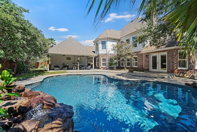 view of pool with french doors, a patio, and ceiling fan