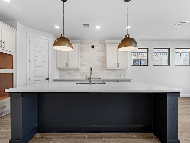 kitchen featuring hanging light fixtures, a large island, and sink