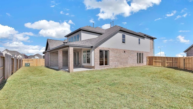 back of property with a lawn and a patio area