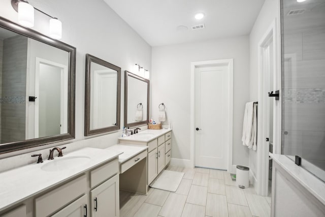 bathroom with a shower with door and vanity