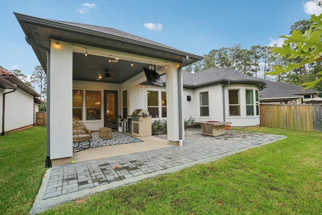 rear view of house with a yard, area for grilling, ceiling fan, and a patio area