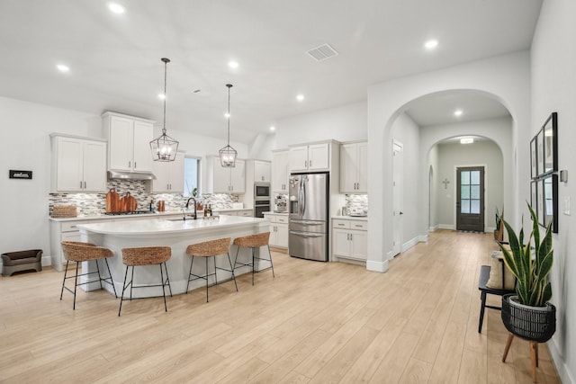 kitchen with white cabinetry, sink, pendant lighting, a center island with sink, and appliances with stainless steel finishes