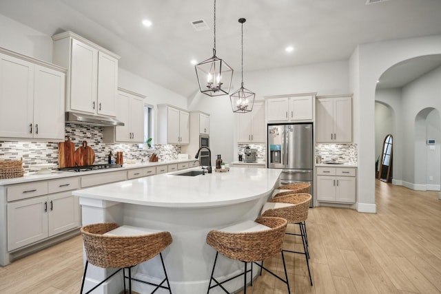 kitchen with a kitchen breakfast bar, sink, an island with sink, and appliances with stainless steel finishes