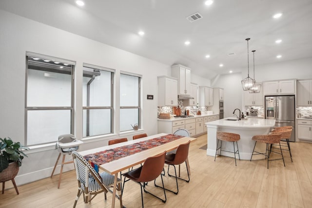 dining space with light wood-type flooring and sink