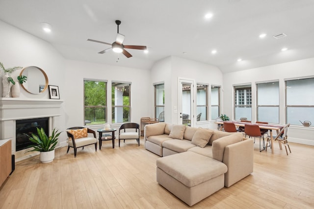 living room featuring ceiling fan, light hardwood / wood-style flooring, and vaulted ceiling