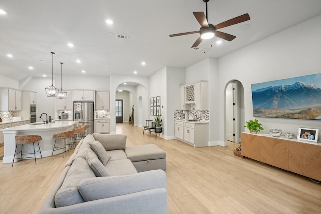 living room with ceiling fan and light hardwood / wood-style flooring