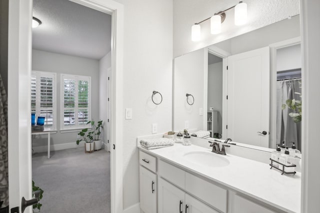 bathroom featuring a textured ceiling and vanity