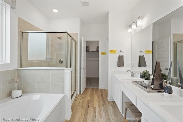 bathroom featuring vanity, hardwood / wood-style flooring, and separate shower and tub