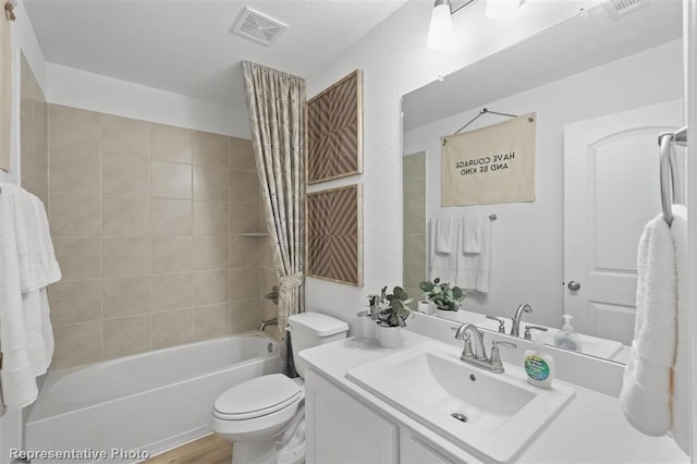 full bathroom featuring toilet, tiled shower / bath combo, vanity, and hardwood / wood-style floors