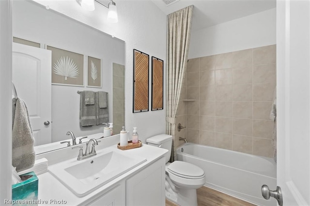 full bathroom featuring hardwood / wood-style flooring, vanity, toilet, and tiled shower / bath combo