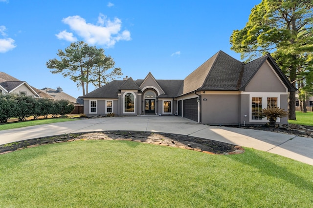 french country style house featuring a garage and a front lawn