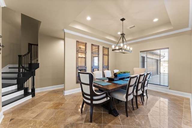 dining space featuring crown molding, a tray ceiling, and an inviting chandelier