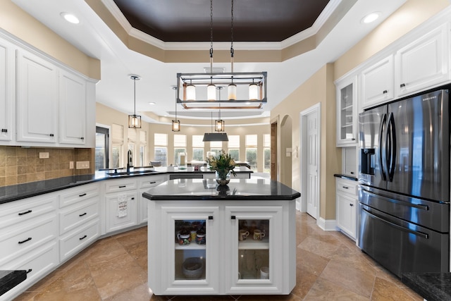 kitchen featuring sink, tasteful backsplash, decorative light fixtures, a center island, and stainless steel fridge