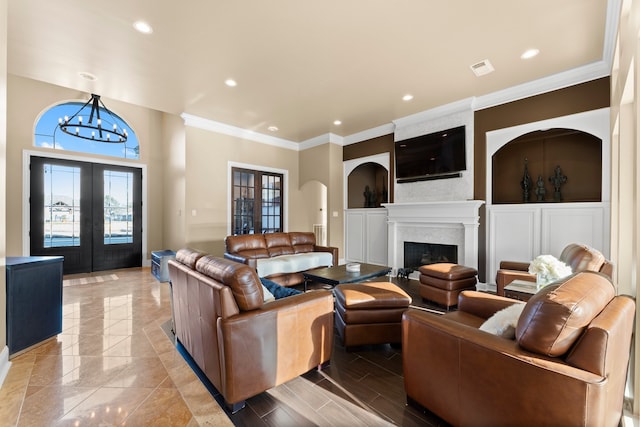 living room with a chandelier, french doors, and crown molding