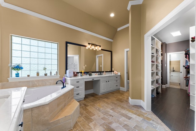 bathroom with vanity, a relaxing tiled tub, and crown molding