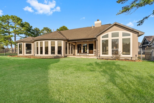 back of property with a sunroom and a yard